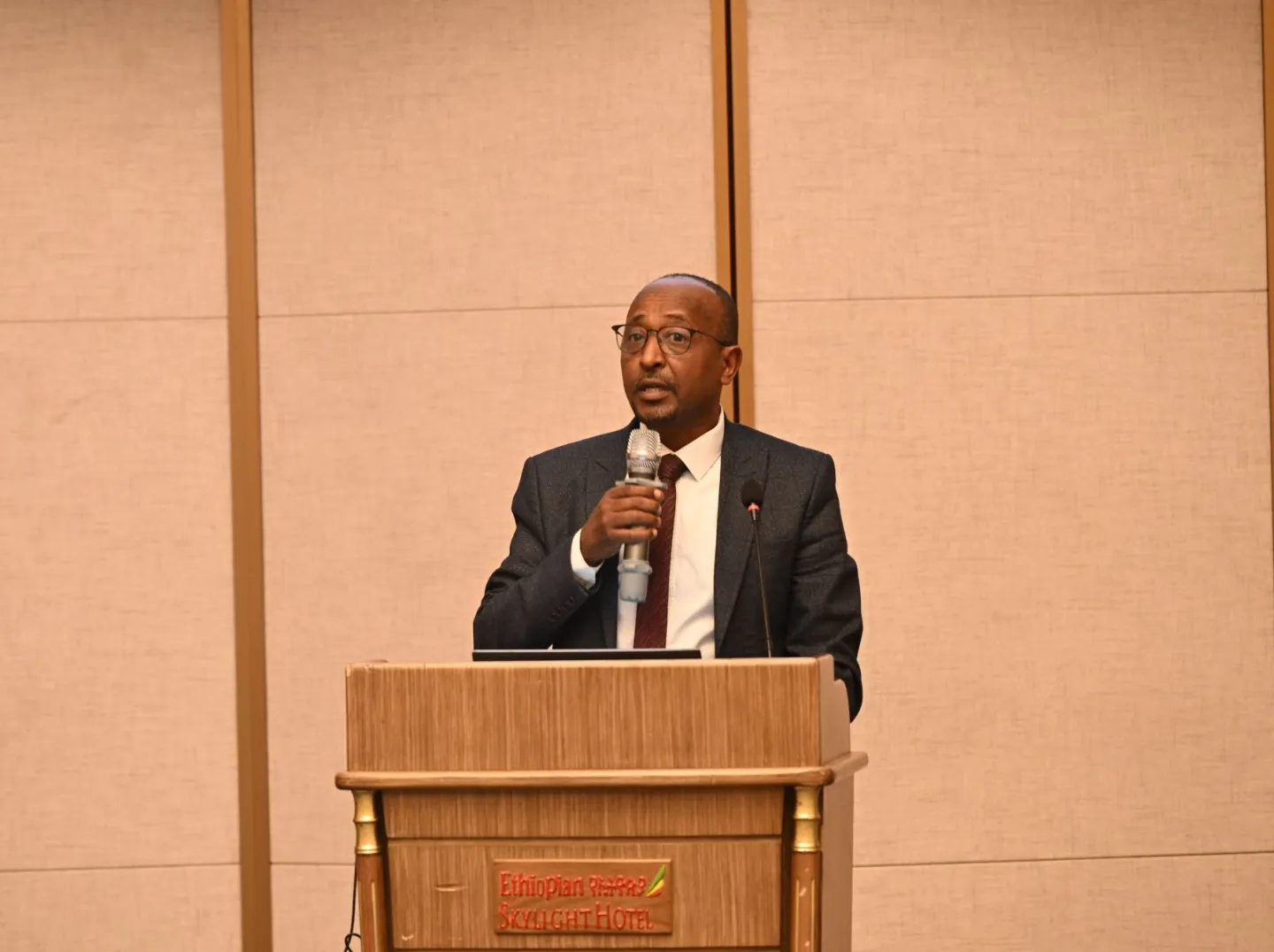 Man speaking infront of an audience. 