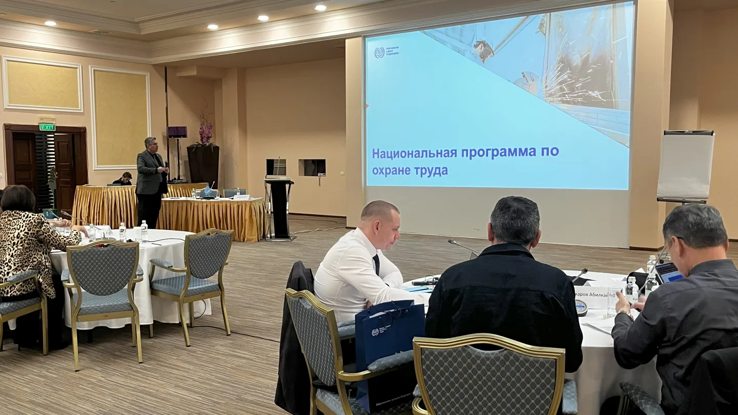 Three participants of the seminar sitting at a round table looking at the screen