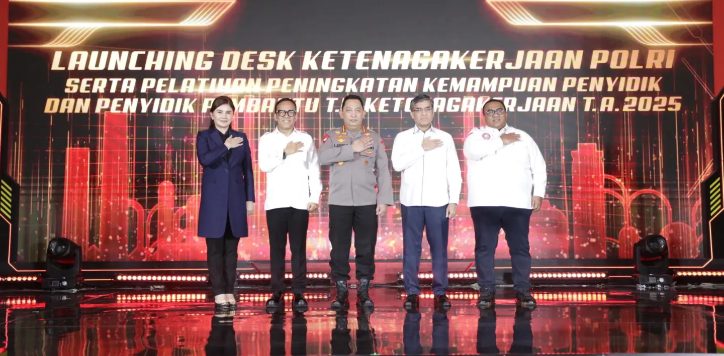 Six people standing on stage with background stating the launch of employment desk