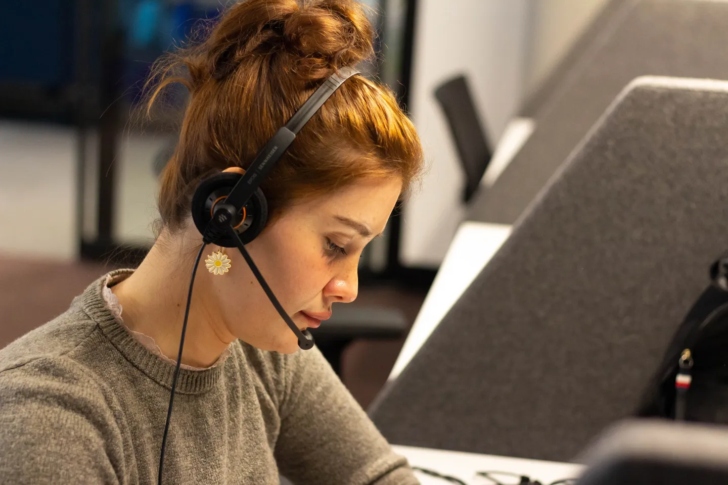 Young woman sitting in front of a computer with a headset