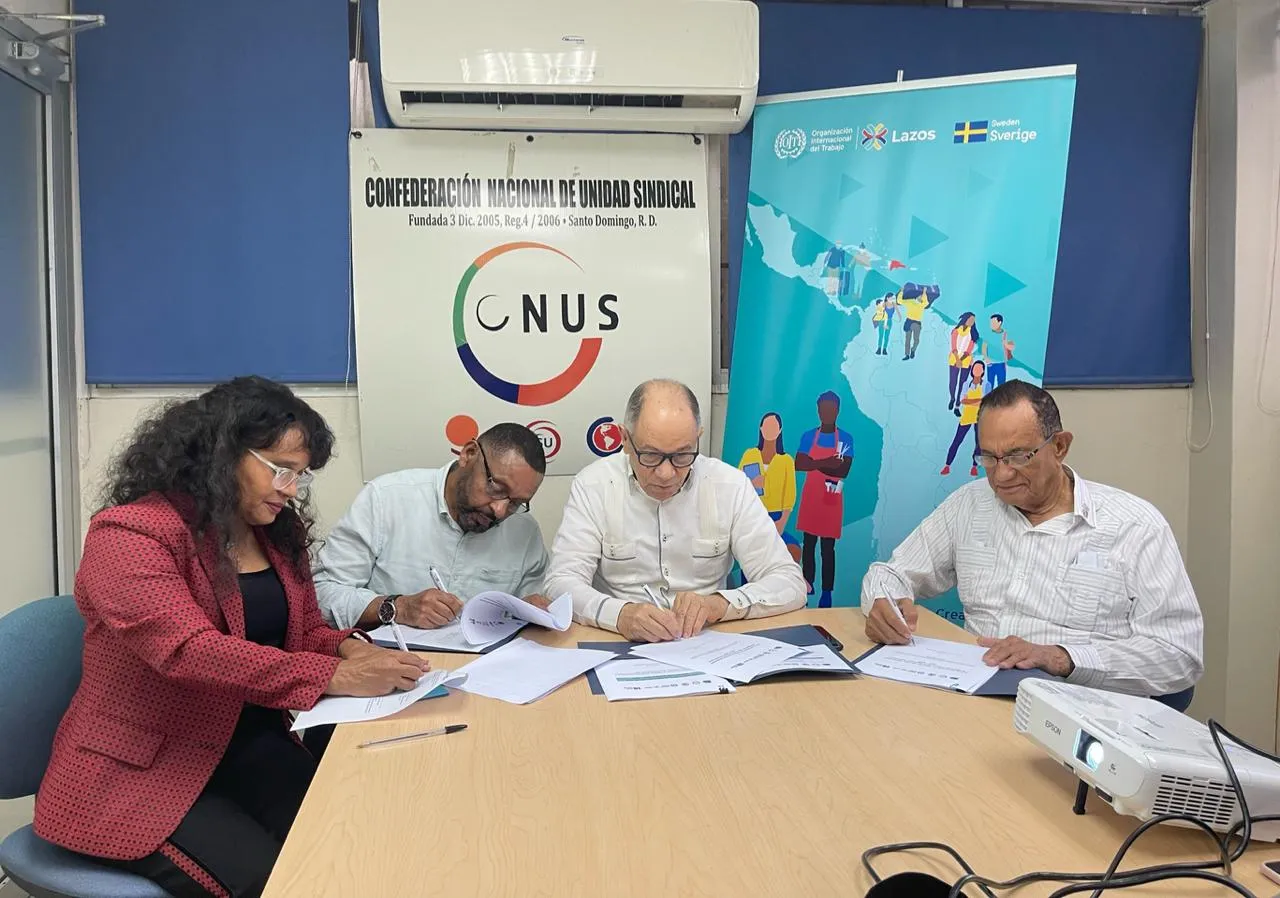 Representantes de las tres centrales sindicales de República Dominicana y Maribel Batista, especialista de la Oficina de Actividades para los Trabajadores (ACTRAV), firman el acta de compromiso para promover la implementación del Plan.