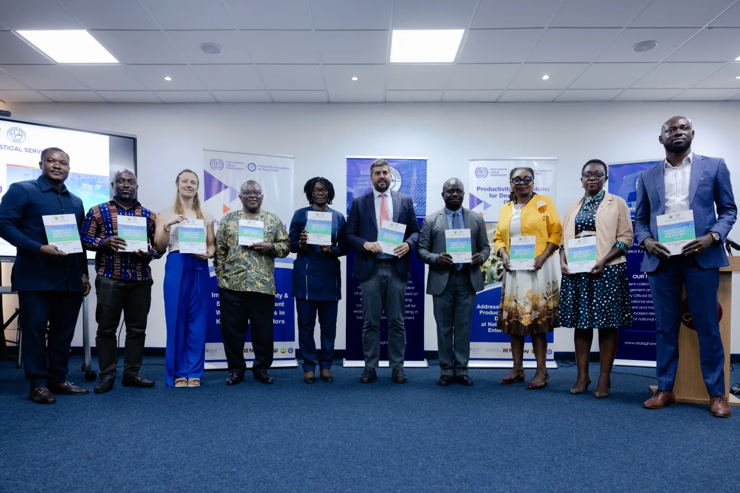 Representatives of ILO, Ghana Statistical Service and key partners in Ghana hold the new report on productivity at the launch event.