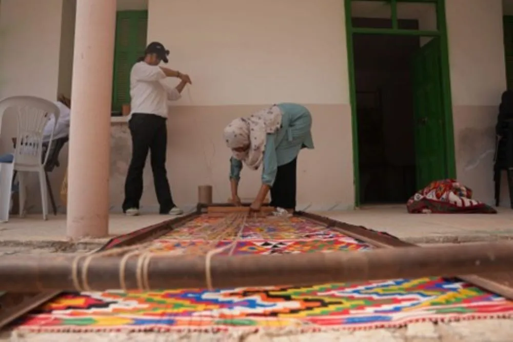 Two generations of women weaving the same tapestry—passing down ancestral skills and empowering future artisans.