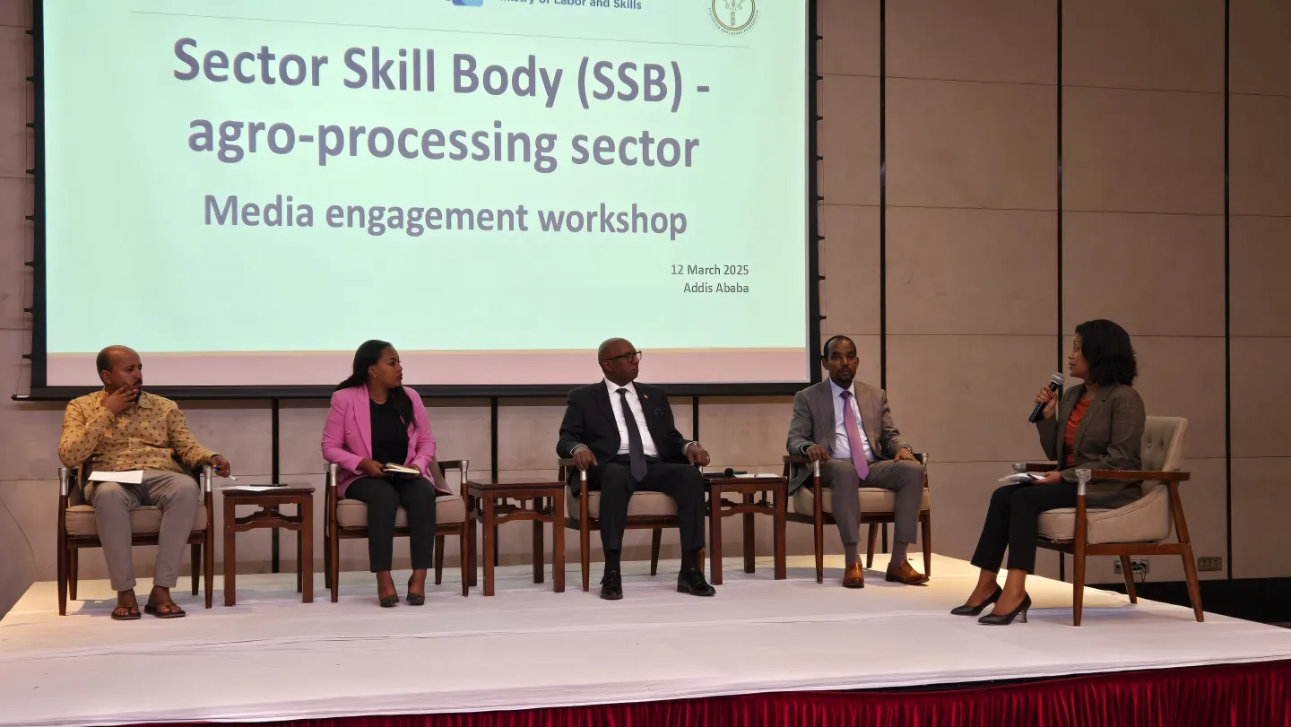 Five panelists leading discussions from the stage 
