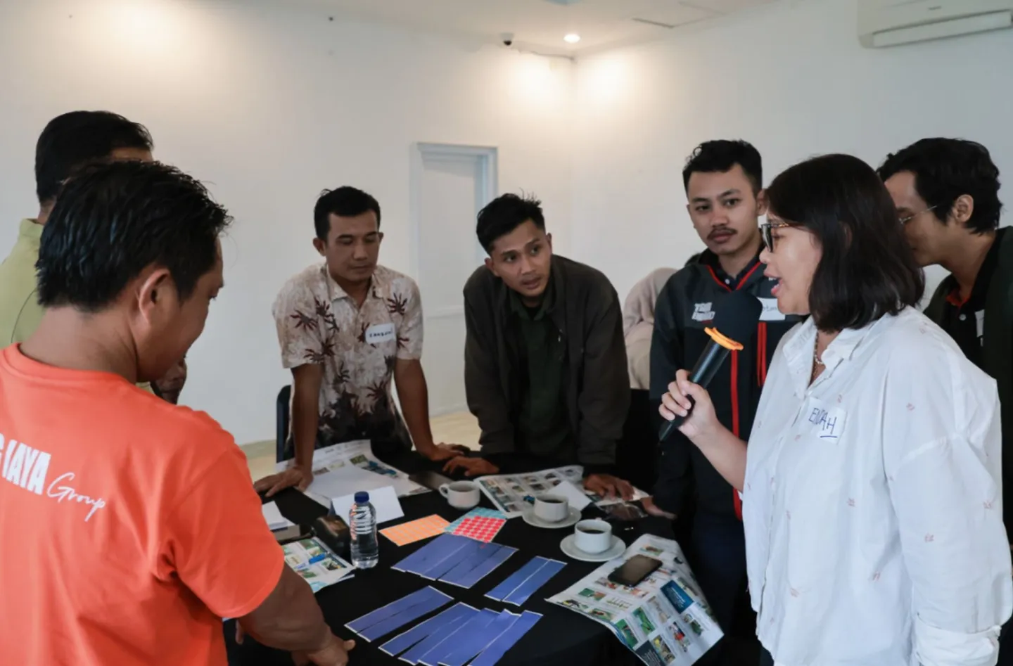 People standing circling a table examining some papers