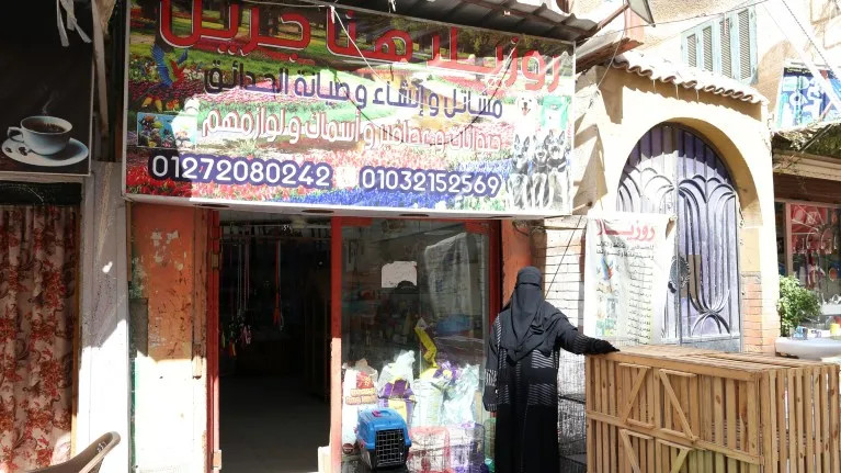 A woman outside her newly opened pet supplies shop in Egypt