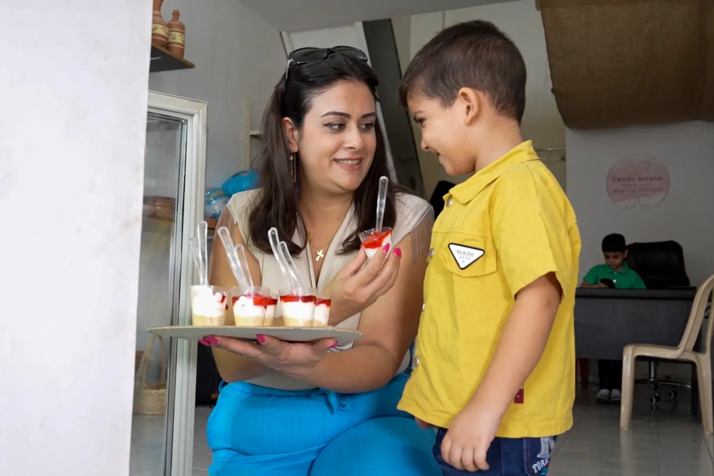 a woman offering a child a desert