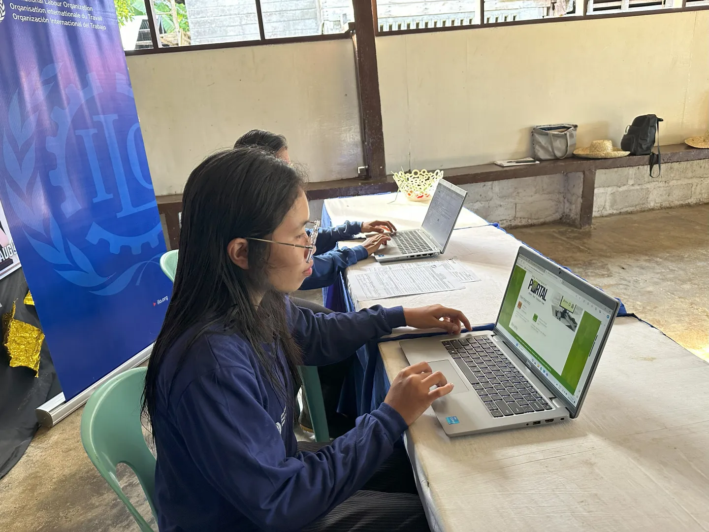Darlyn uses a computer to register for social protection and health insurance coverage.
