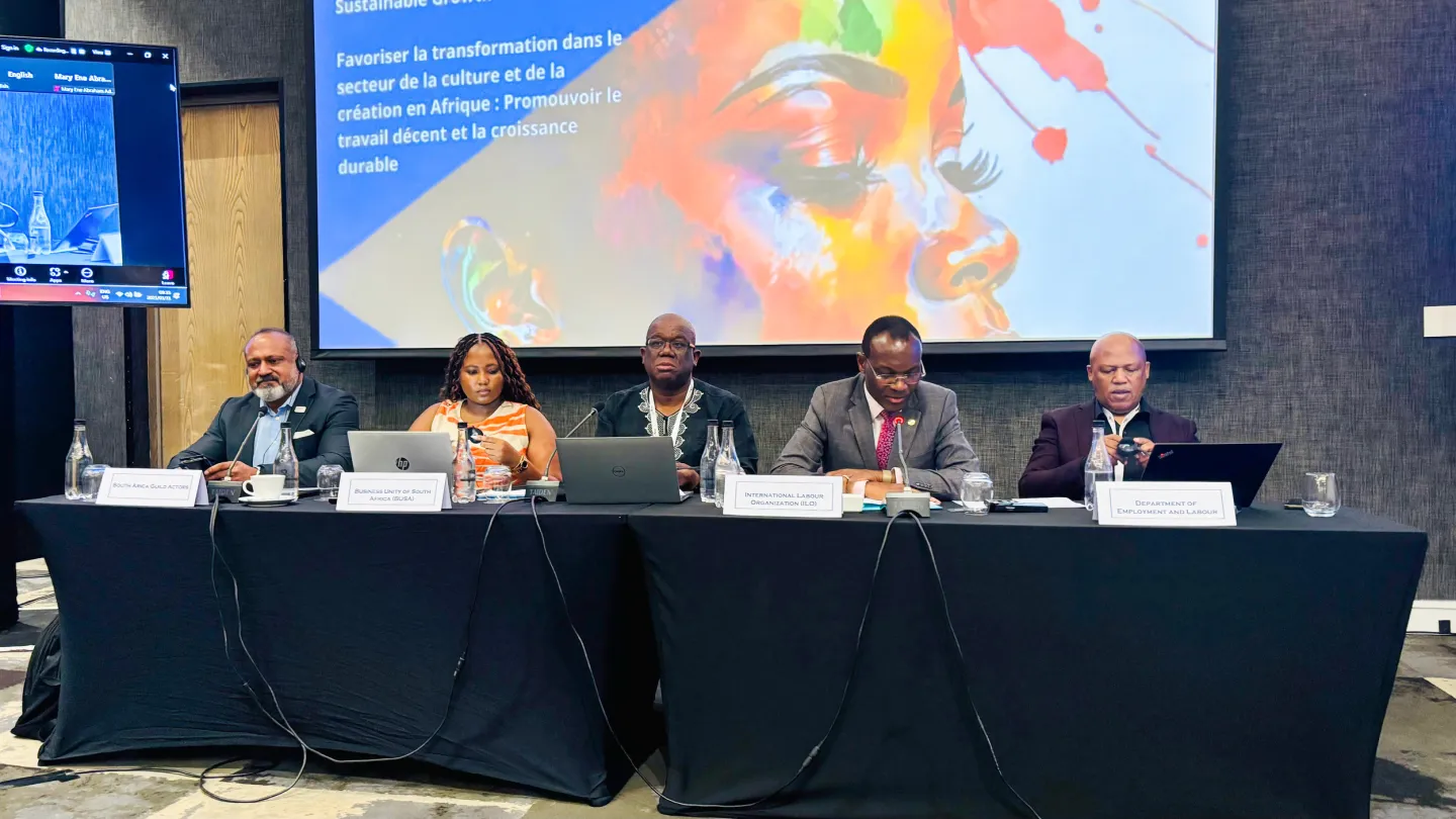 Panel of five speakers seated at a conference table during a session on promoting decent work and sustainable growth in Africa's cultural and creative sector.