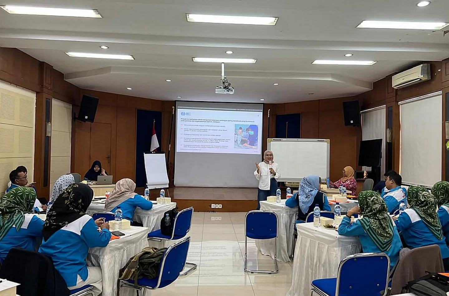 Gender training with participants seating facing a screen.
