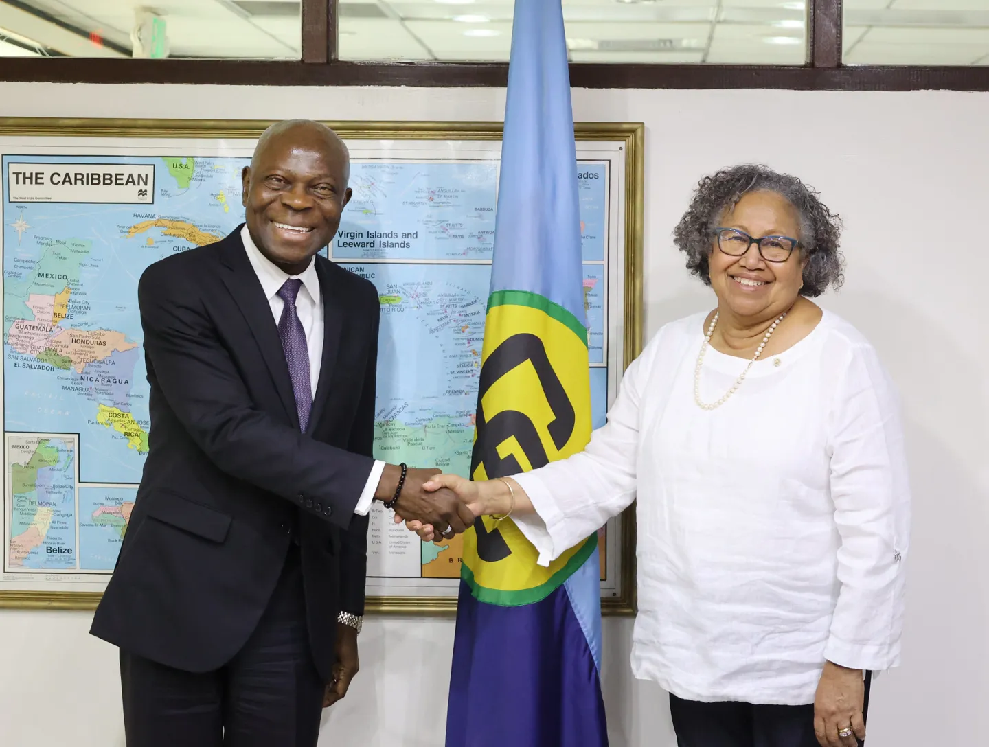 ILO Director-General Gilbert F. Houngbo shakes hands with Dr. Carla Barnett, Secretary-General of CARICOM