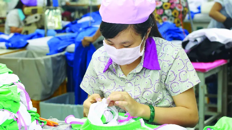 A women worker sewing clothes.