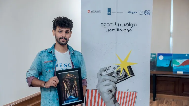 Ayamen posing with the frame of his photograph displayed at the event 