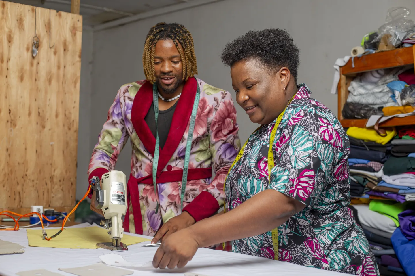 Clothing designers, Kudzi Chibi and his mother examining some fabric