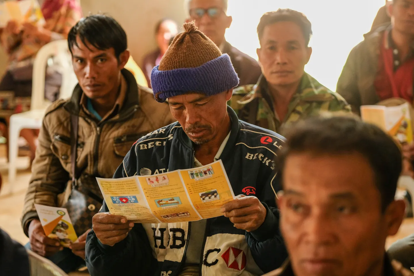 A farmer is reading LSSO brochure on social security benefits