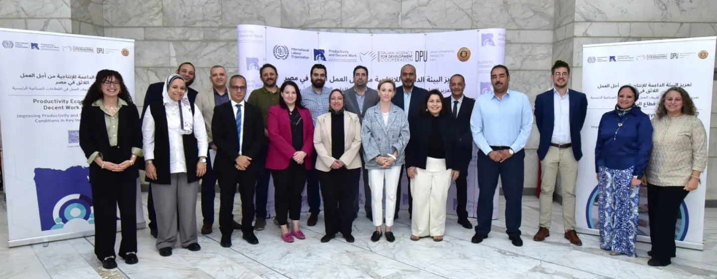 Participants gather in front of a banner during the second day of a validation workshop on Egypt's leather and marble industries in Cairo.