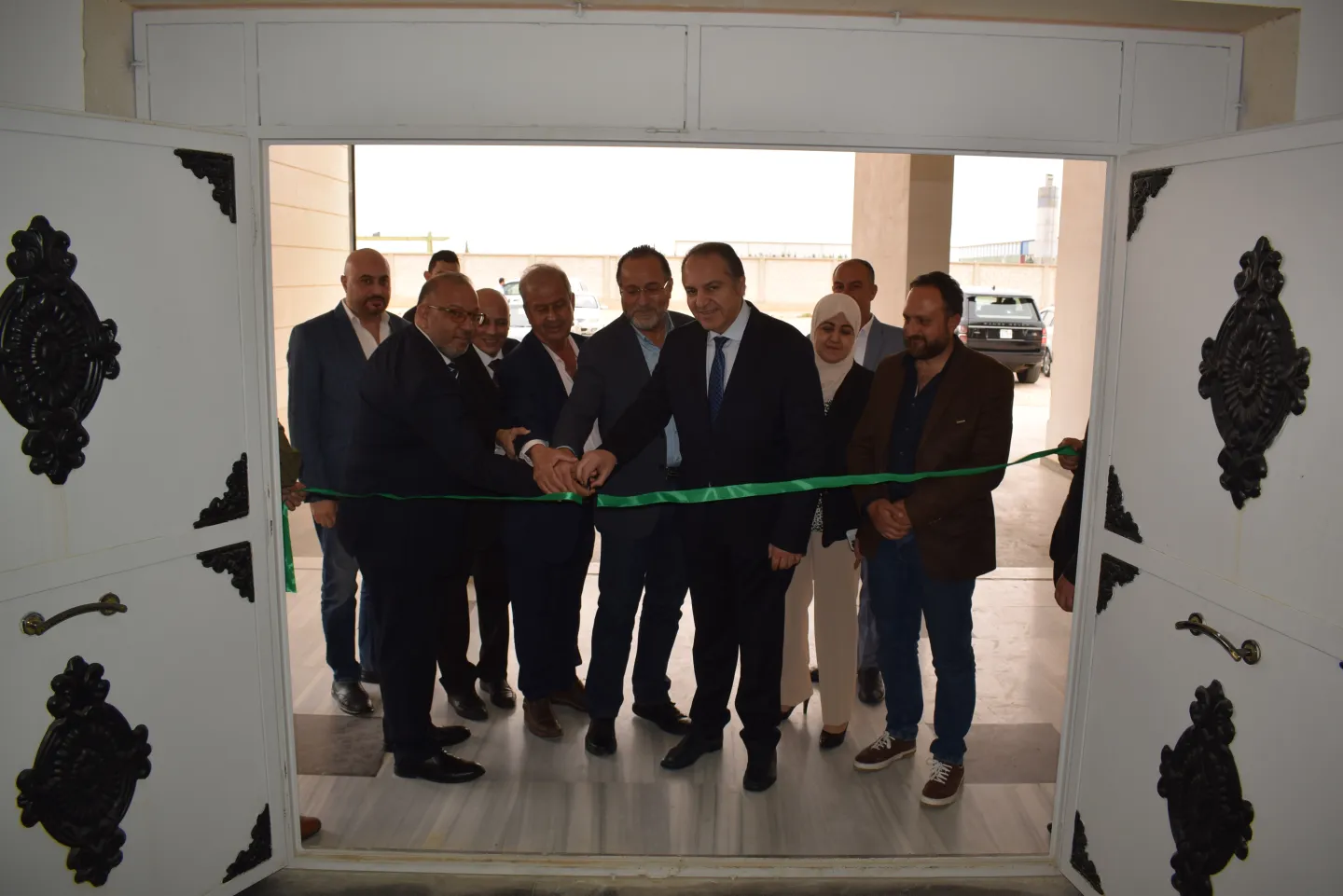 A group waiting excitedly in front of a ribbon to open the Human and Vocational Resource Development Centre in Syria