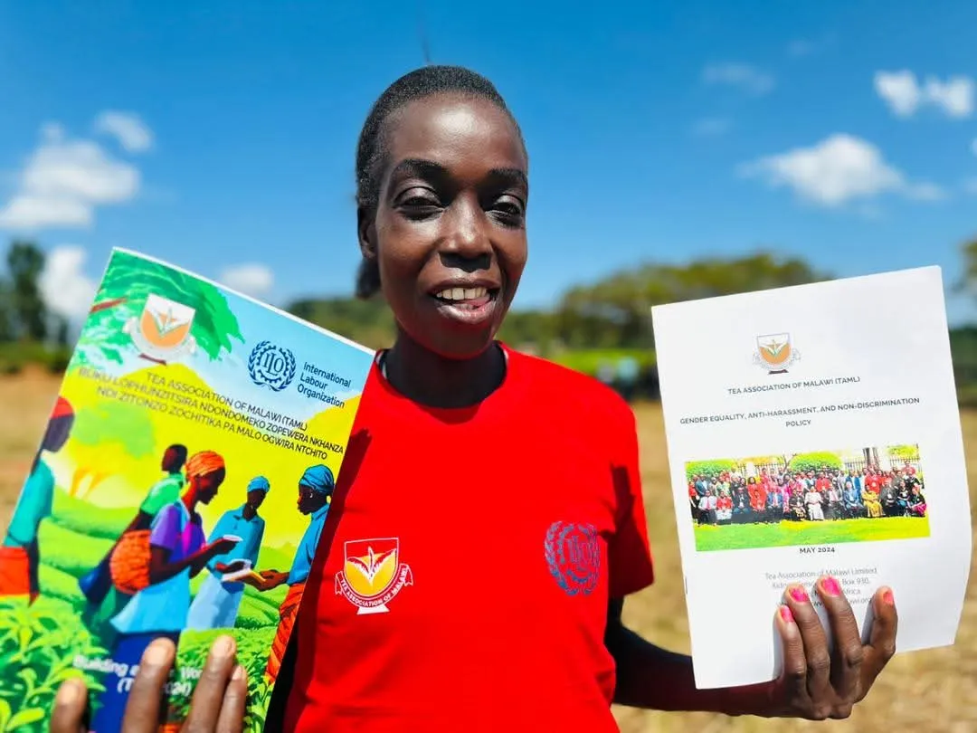 A lady in red holds the policy and training guide.
