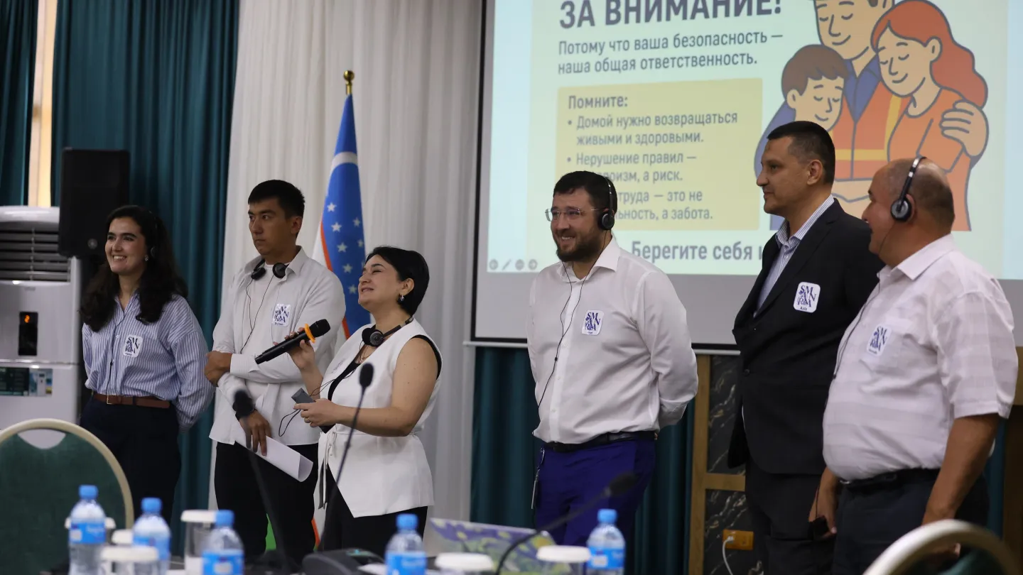 A group of people standing in front of a screen
