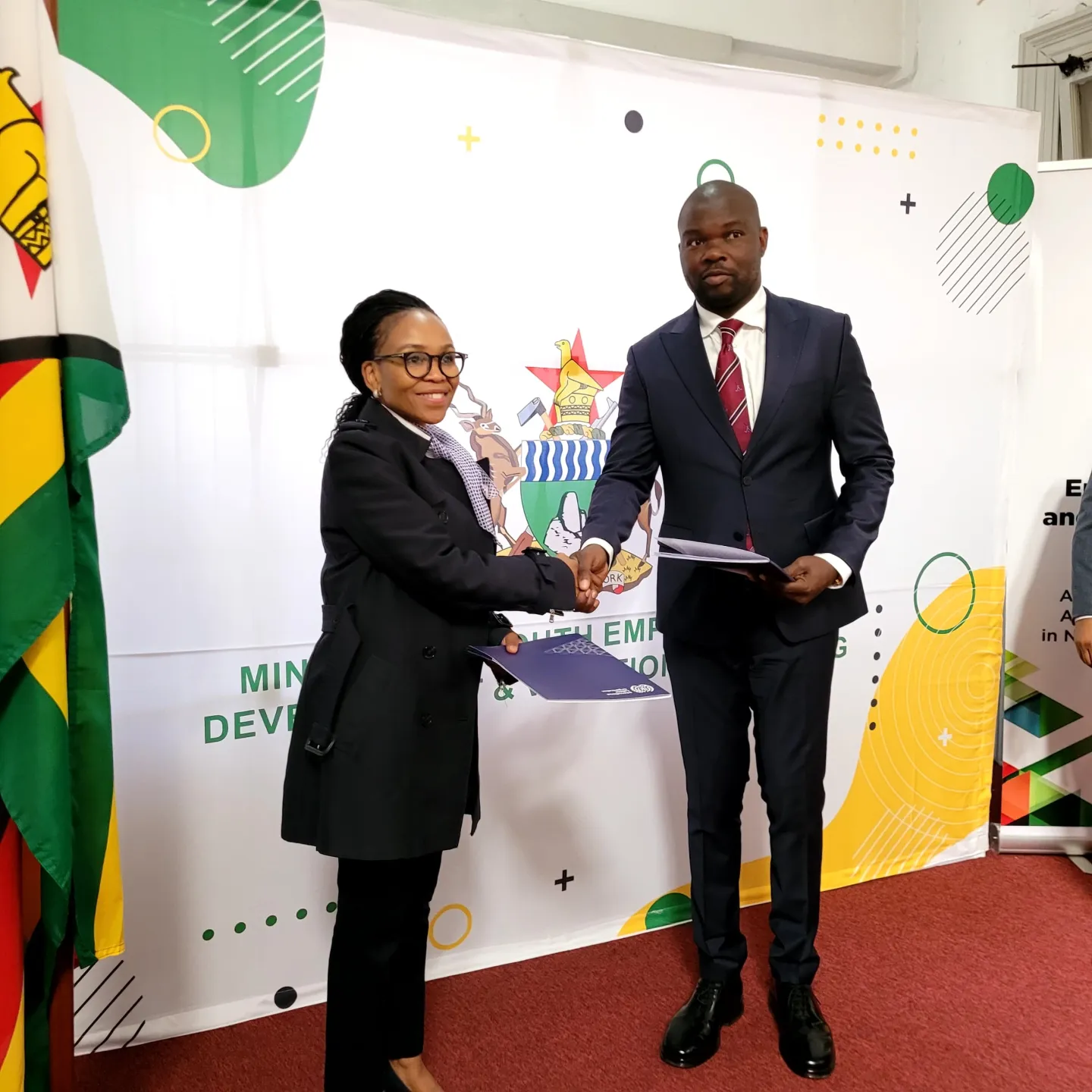Youth Minister Machakaire shake hands with ILO Director Philile Masuku after the handover document signing ceremony