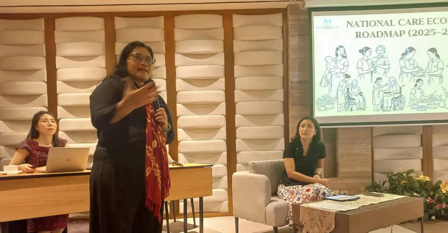 Three women, two sitting and one standing