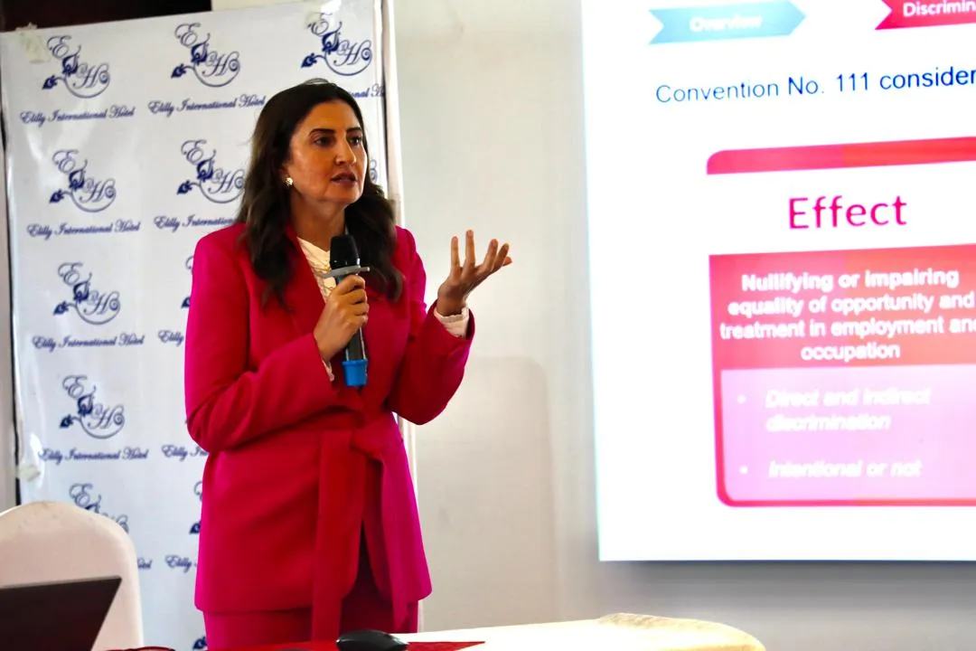 A woman speaking infront of an audience. 