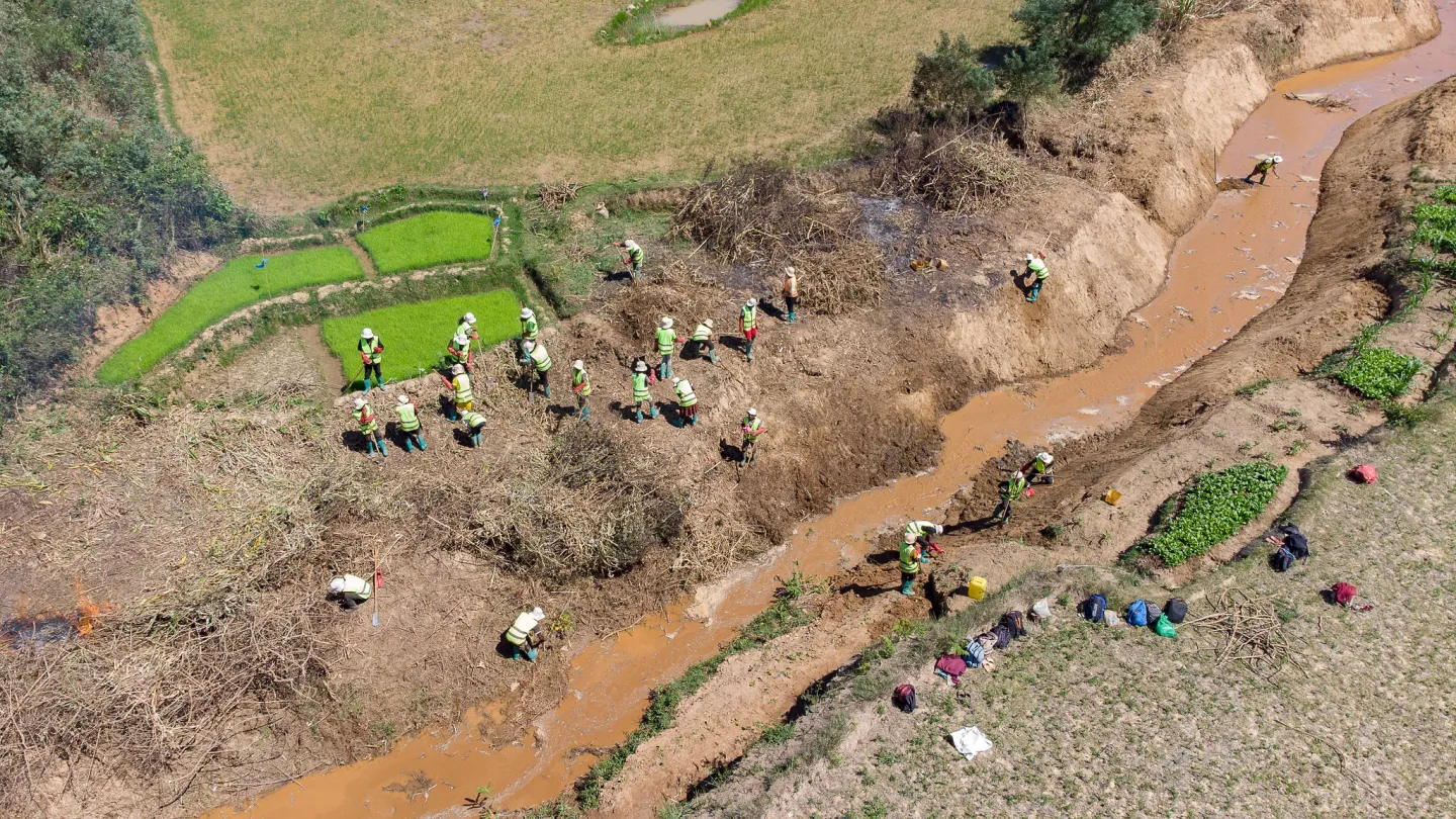 aerial view of irrigation canal with worker in protective gear