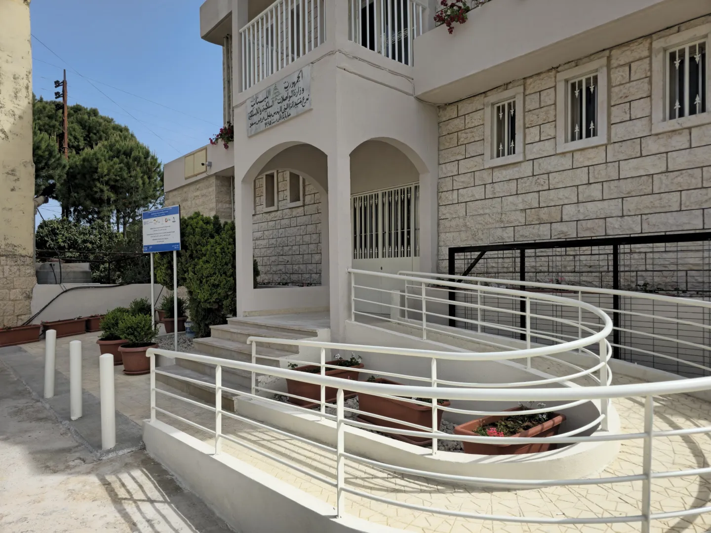 the photo show a white accessibility ramp installed in front of the municipality building in Deddeh