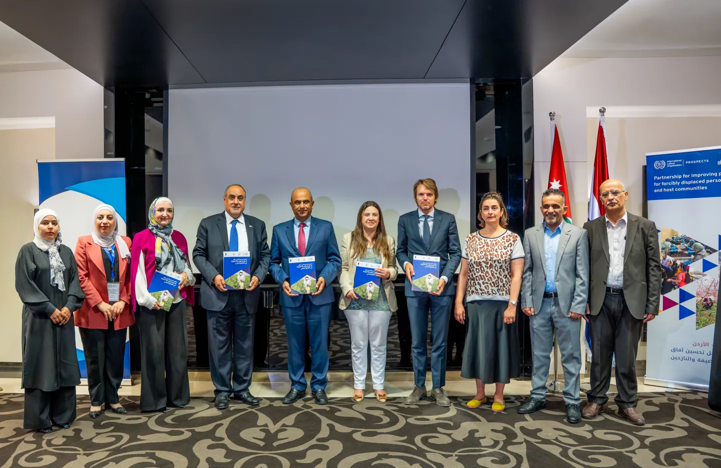 Delegates present at the launch workshop posing for a photo with copies of guide