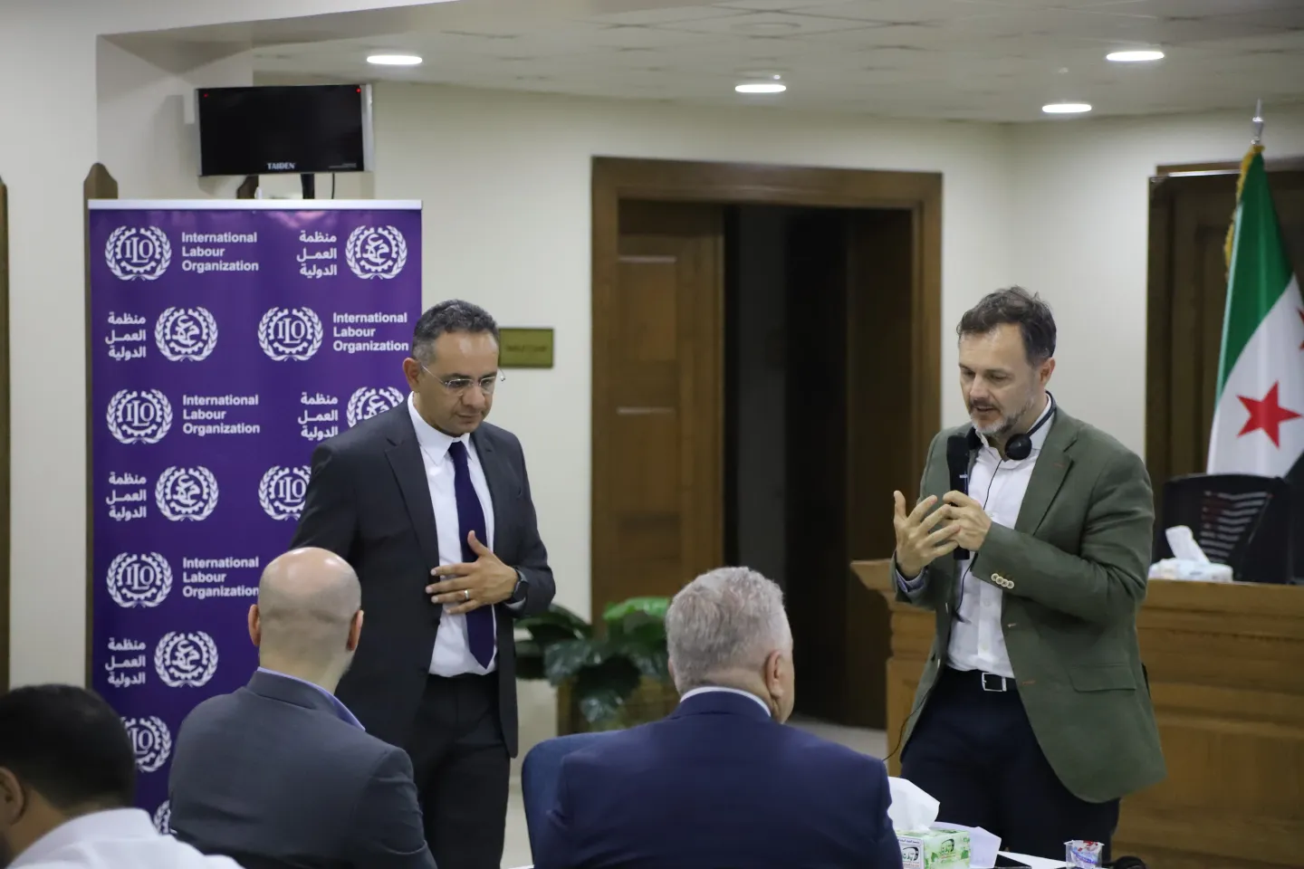2 men speaking in front of an audience