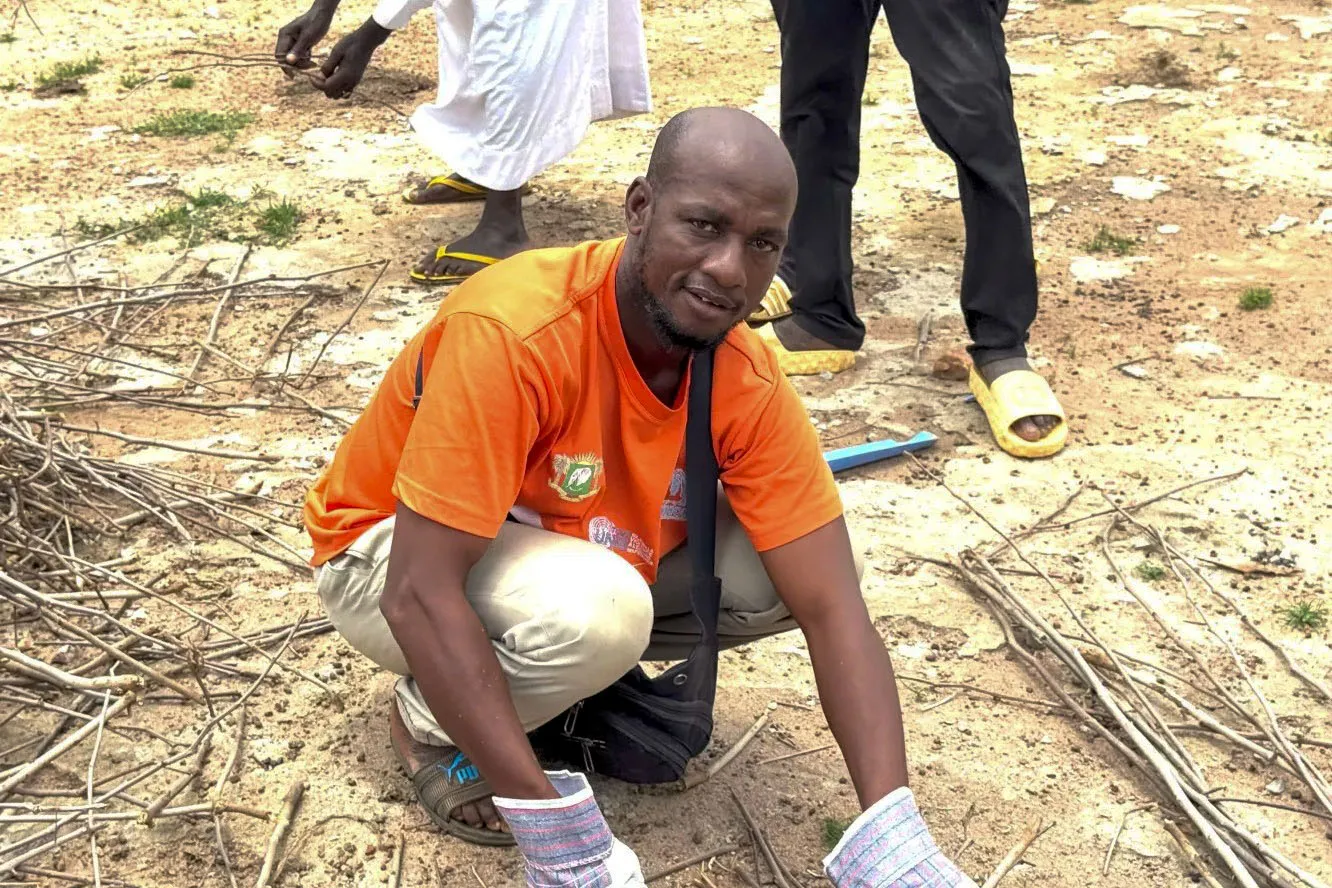 Diallo Koundja prépare la biomasse, premier geste vers une nouvelle vie grâce au biochar.
