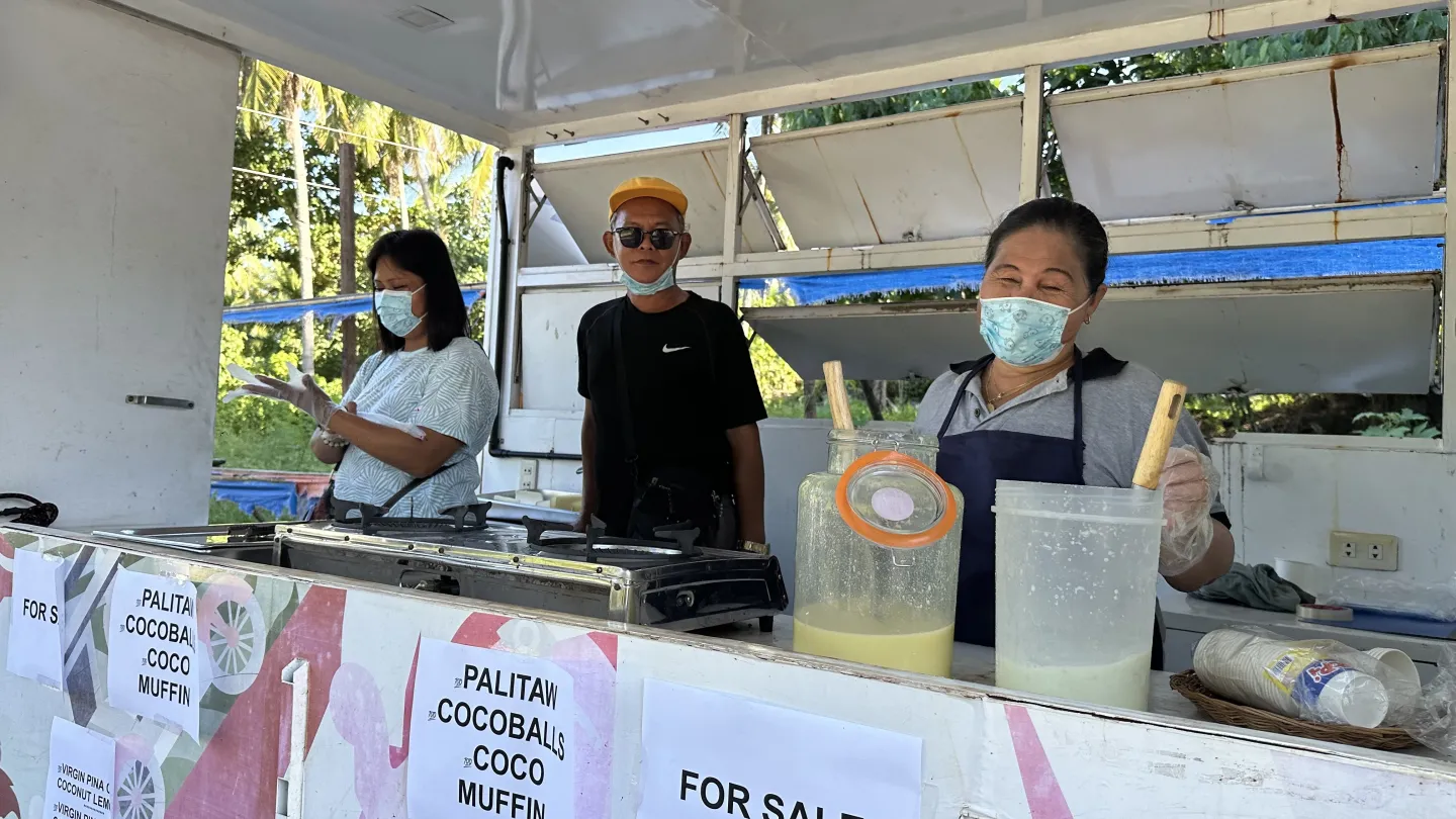 Rolly sells coconut drinks via a food cart.