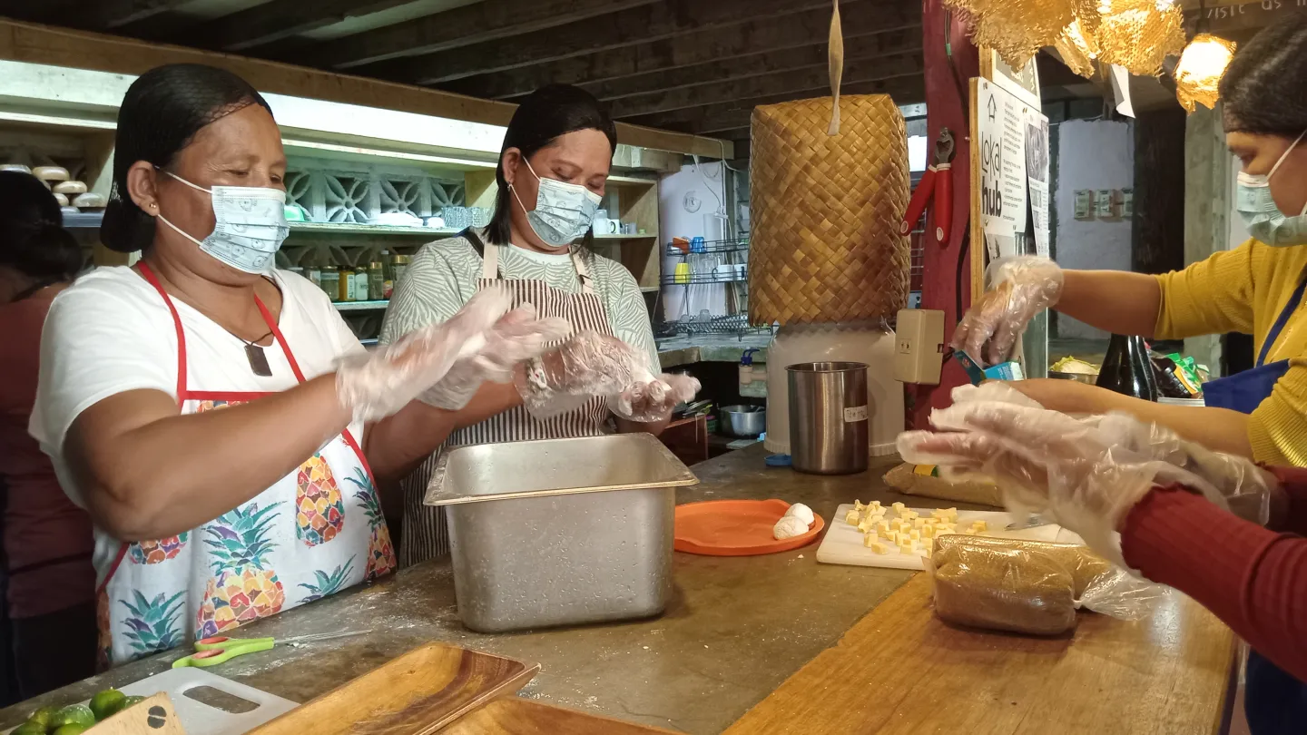 Three women making coco balls during a coconut culinary training.
