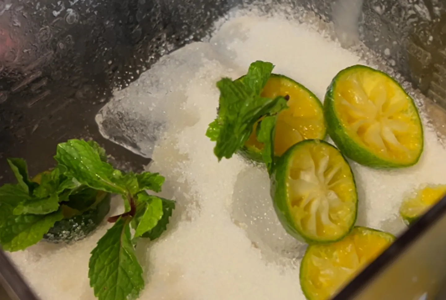 Calamansi and mint leaves on top of ice with coconut milk.