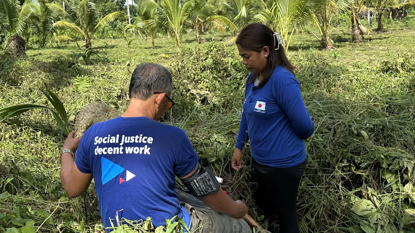 Jonalyn checks the blood pressure of a coconut farm worker.