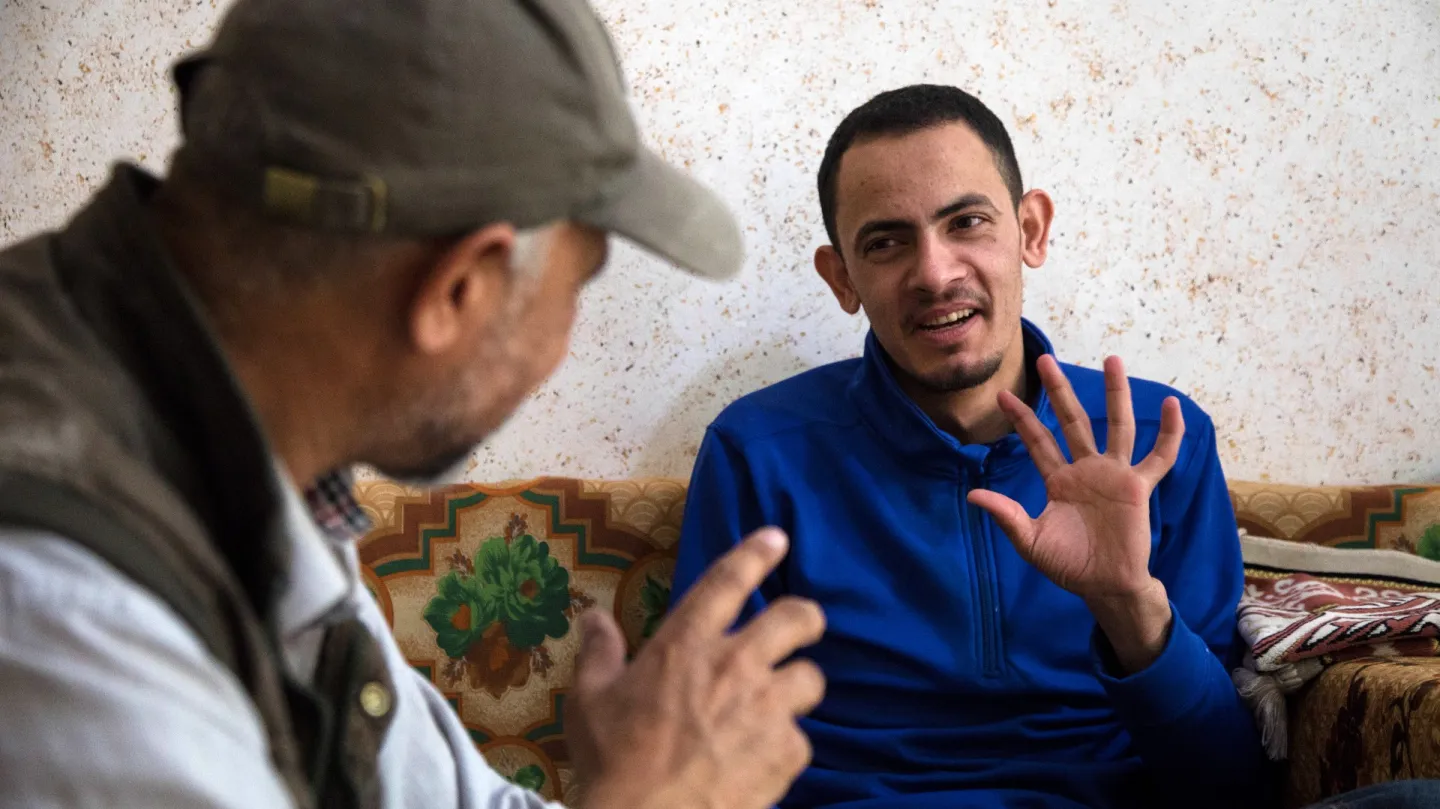Using sign language Ahmed's father supports him to understand work and qualification requirements 
