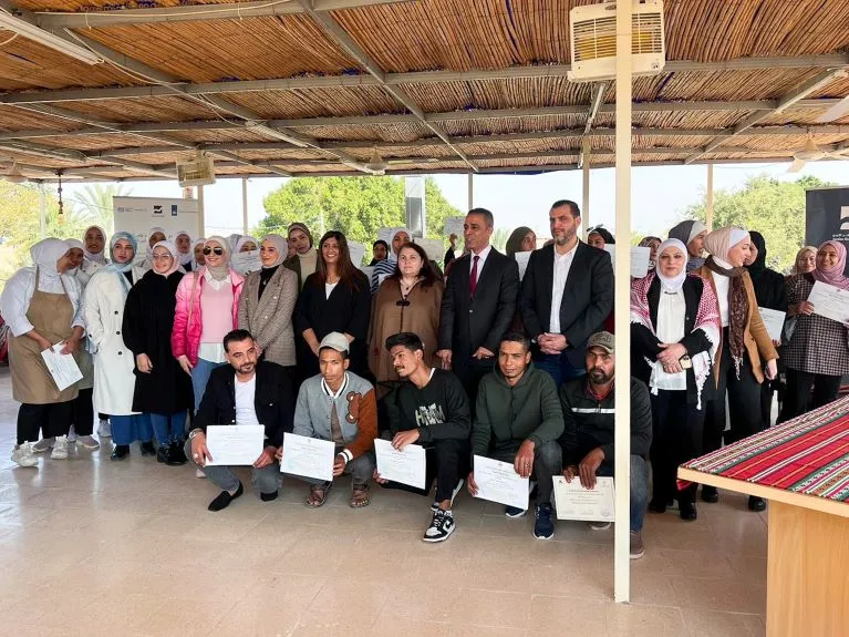 Jordanian and Syrian WBL-graduates are seen with officials from the ILO and implementing partners during their graduation ceremony in Jordan