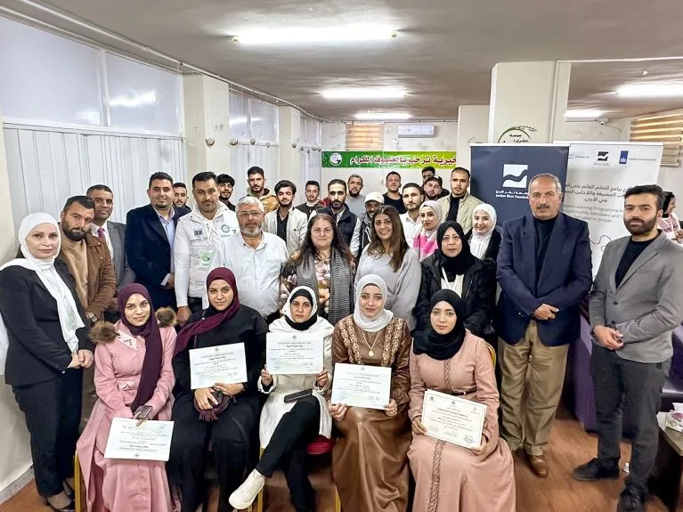 Jordanian and Syrian WBL-graduates are seen with officials from the ILO and implementing partners during their graduation ceremony in Jordan