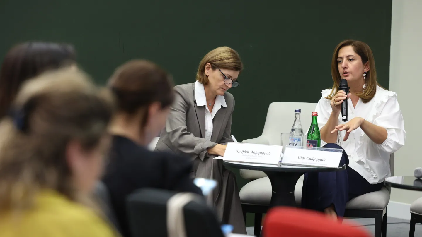Woman speaking into a mic in front of audience