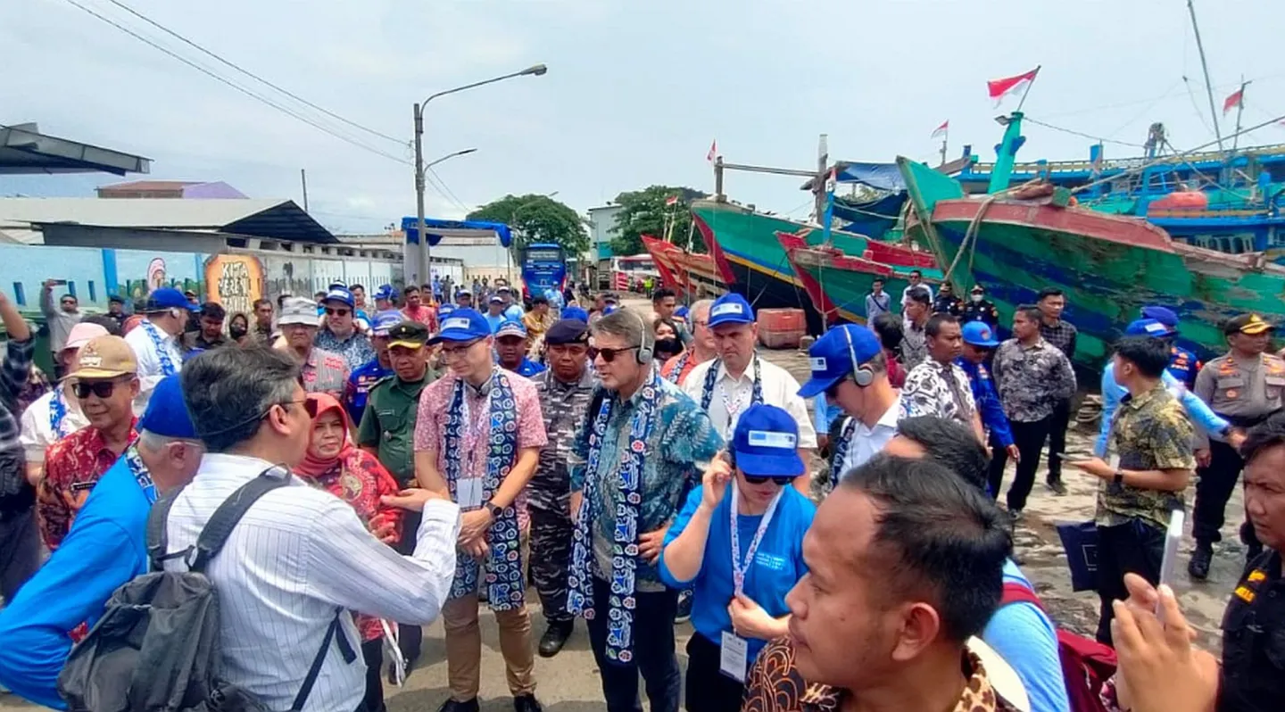 A group of people standing in fishing port
