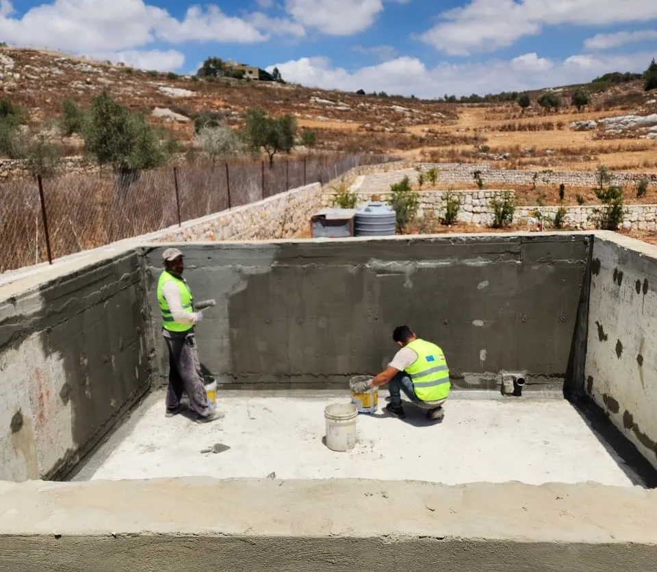 Workers plastering a newly built water tank to support irrigation and farming. Lebanon, 2025