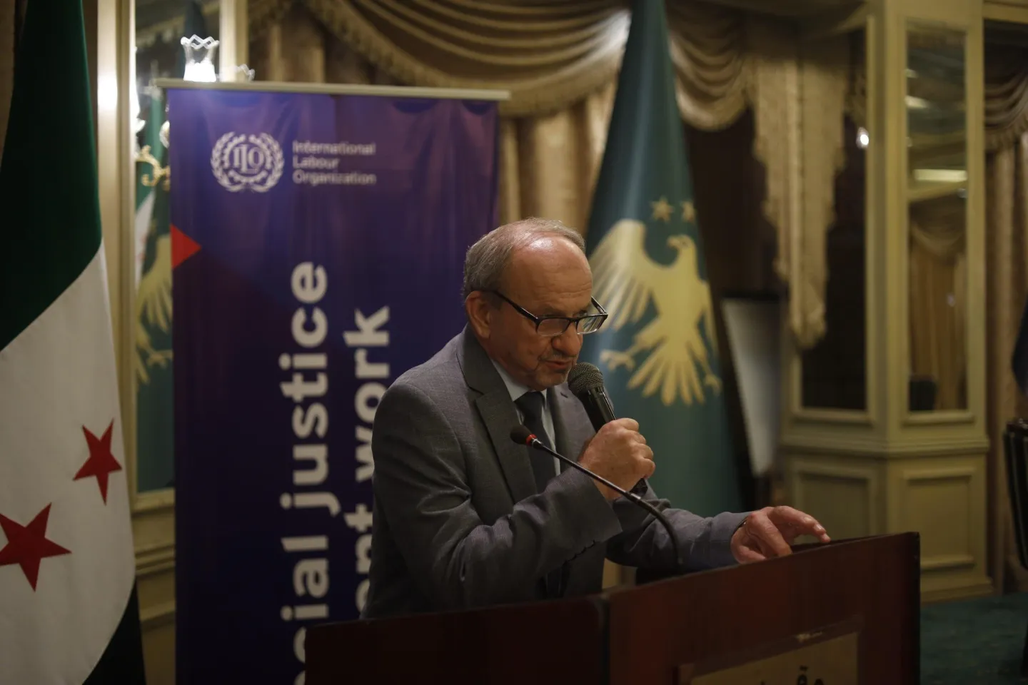 President of Syrian Chambers of Industry in Syria speaking at a podium