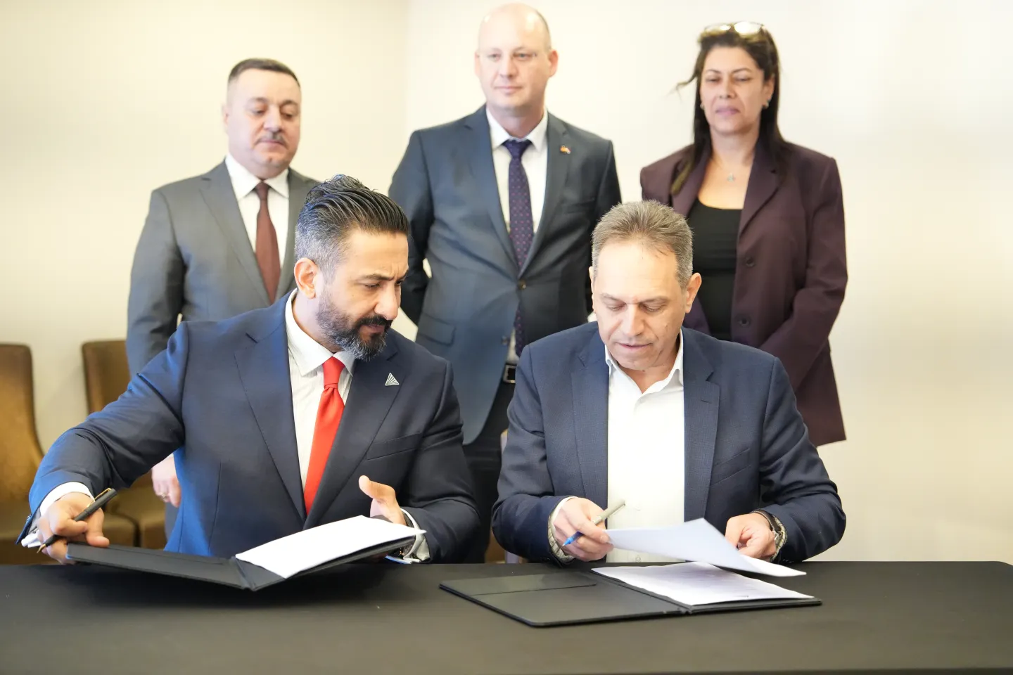 Representatives from the Iraqi Company for Bank Guarantees signing documents