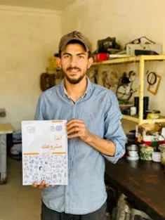 man from iraq showing his training materials papers