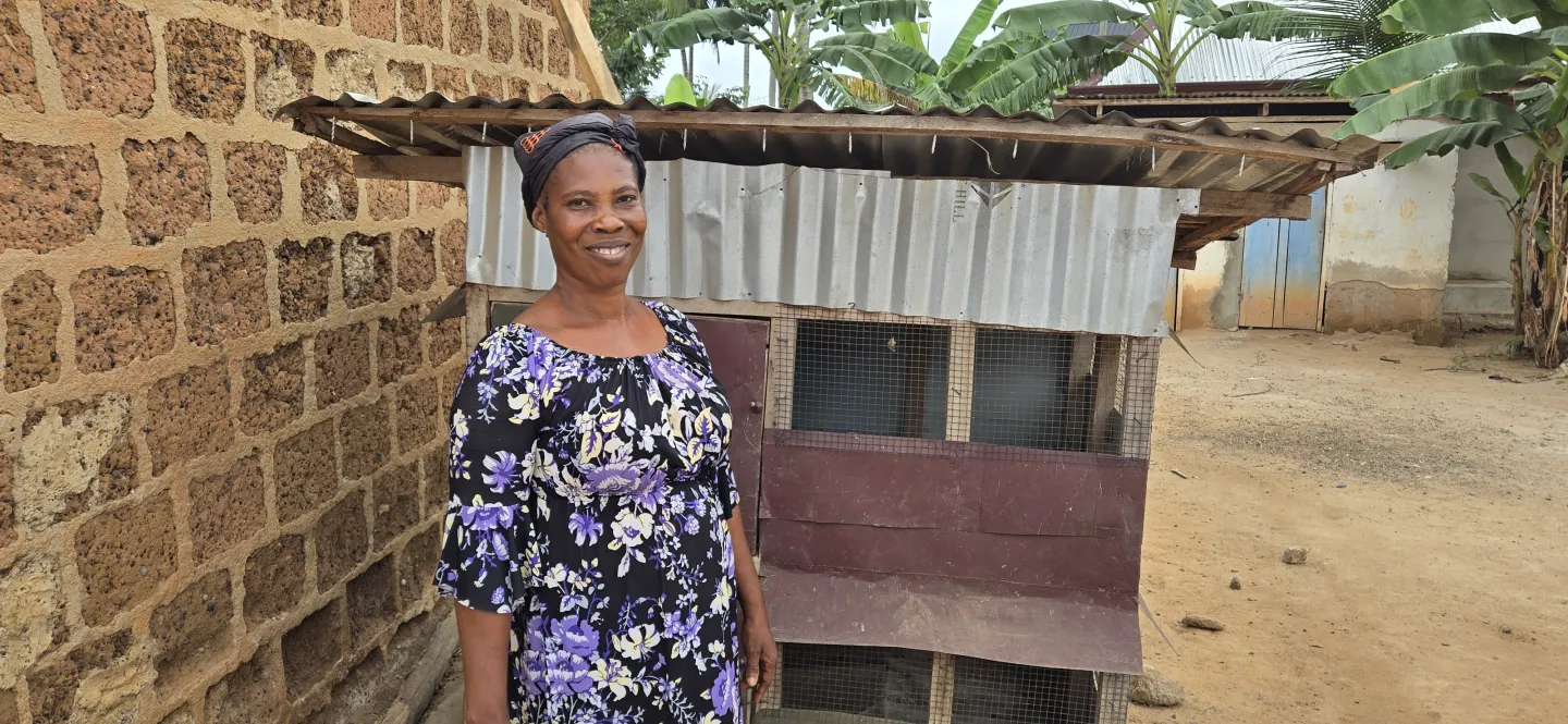Vida stands next to her hen coop