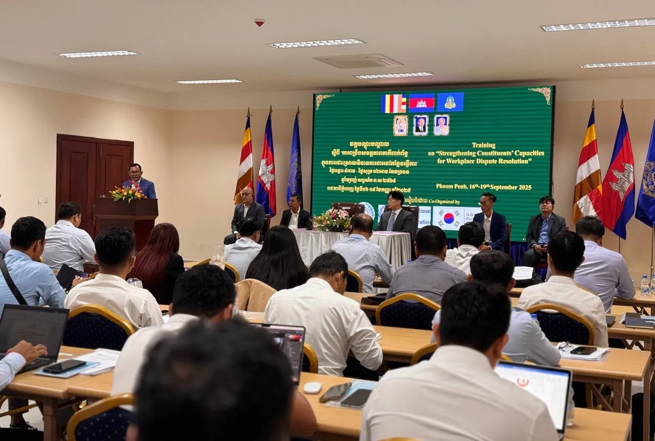 A speaker addresses the audience from the podium as participants listen.