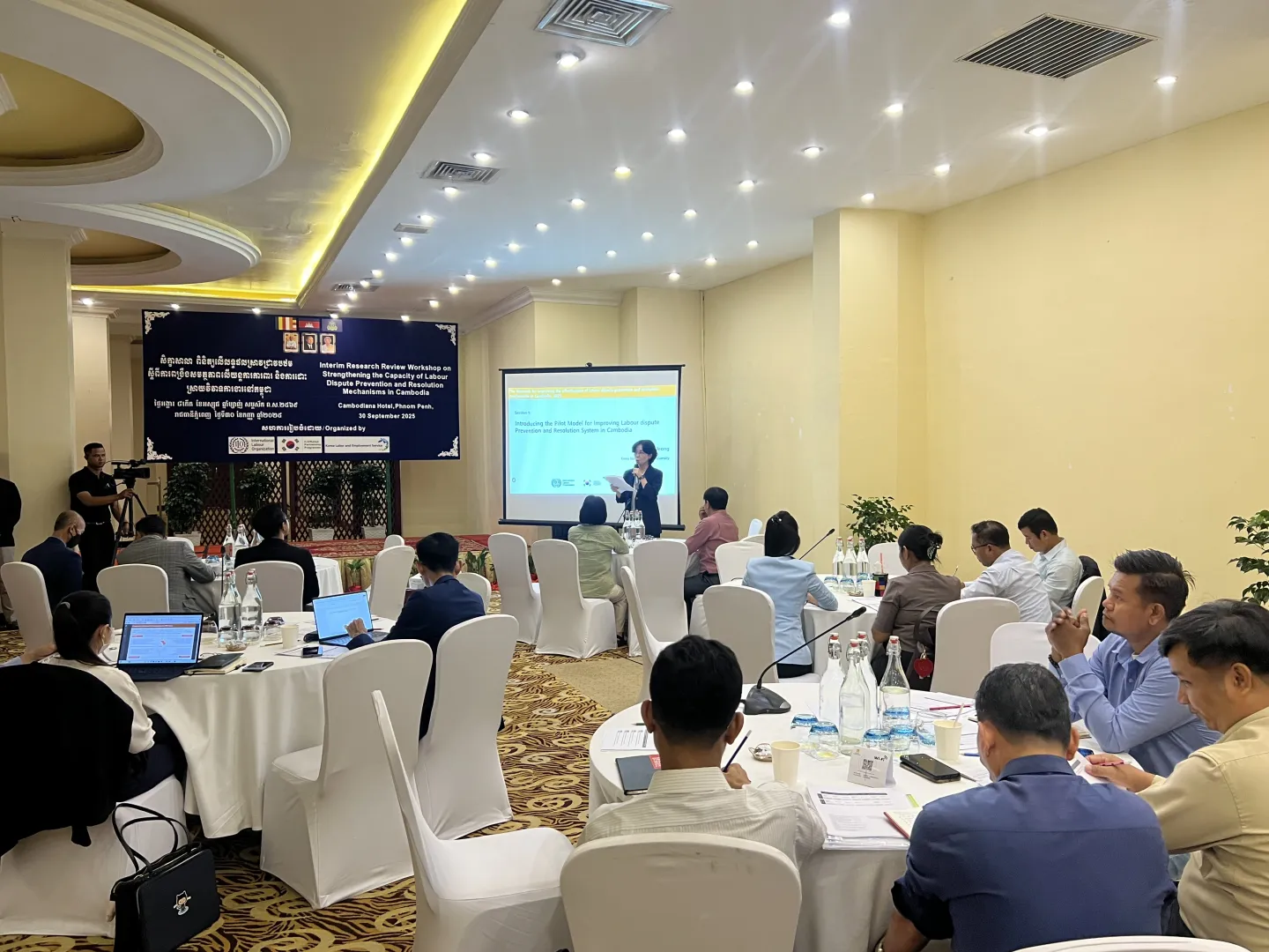 One is presenting in a large meeting room.
