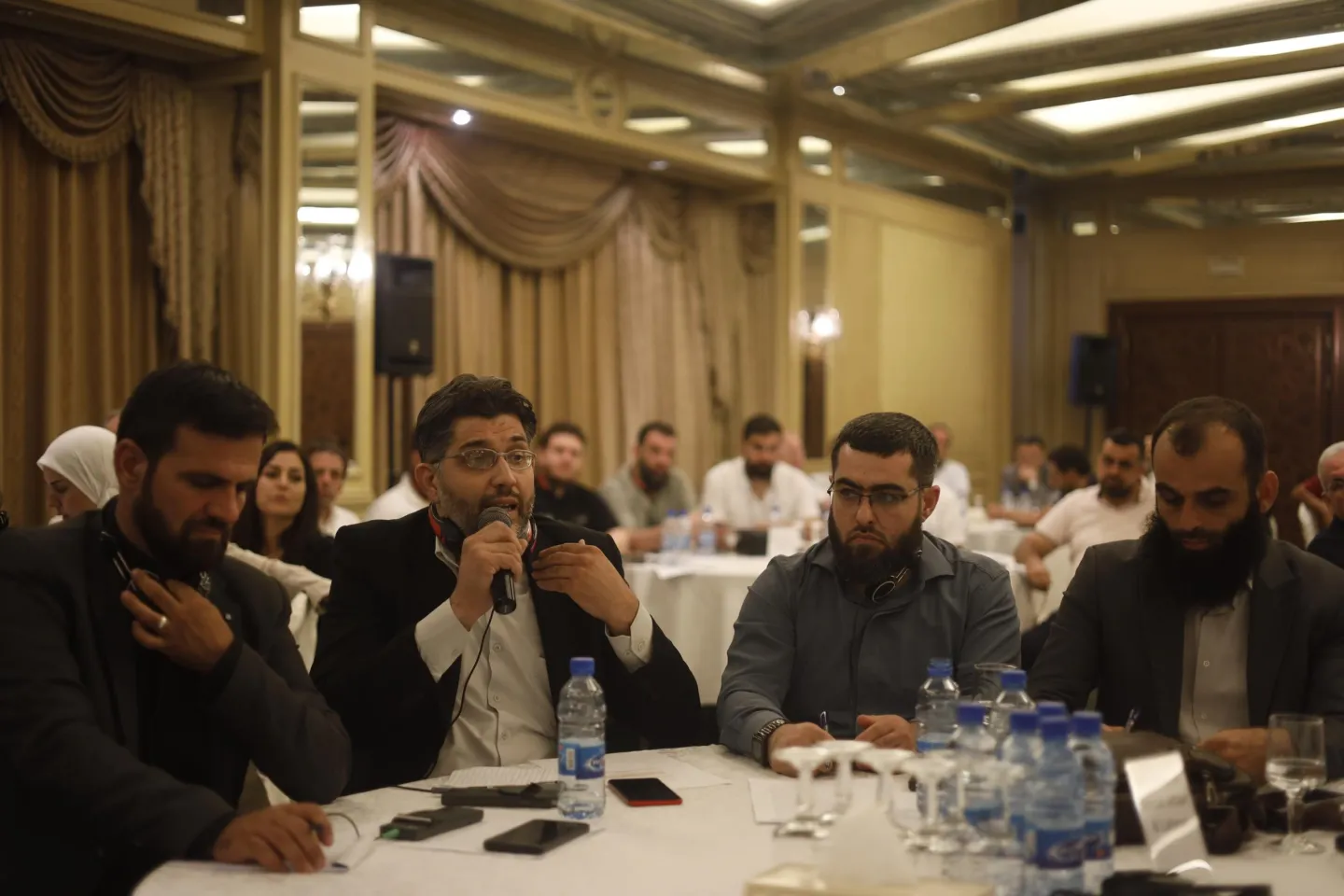 A man speaking into microphone at meeting in Iraq