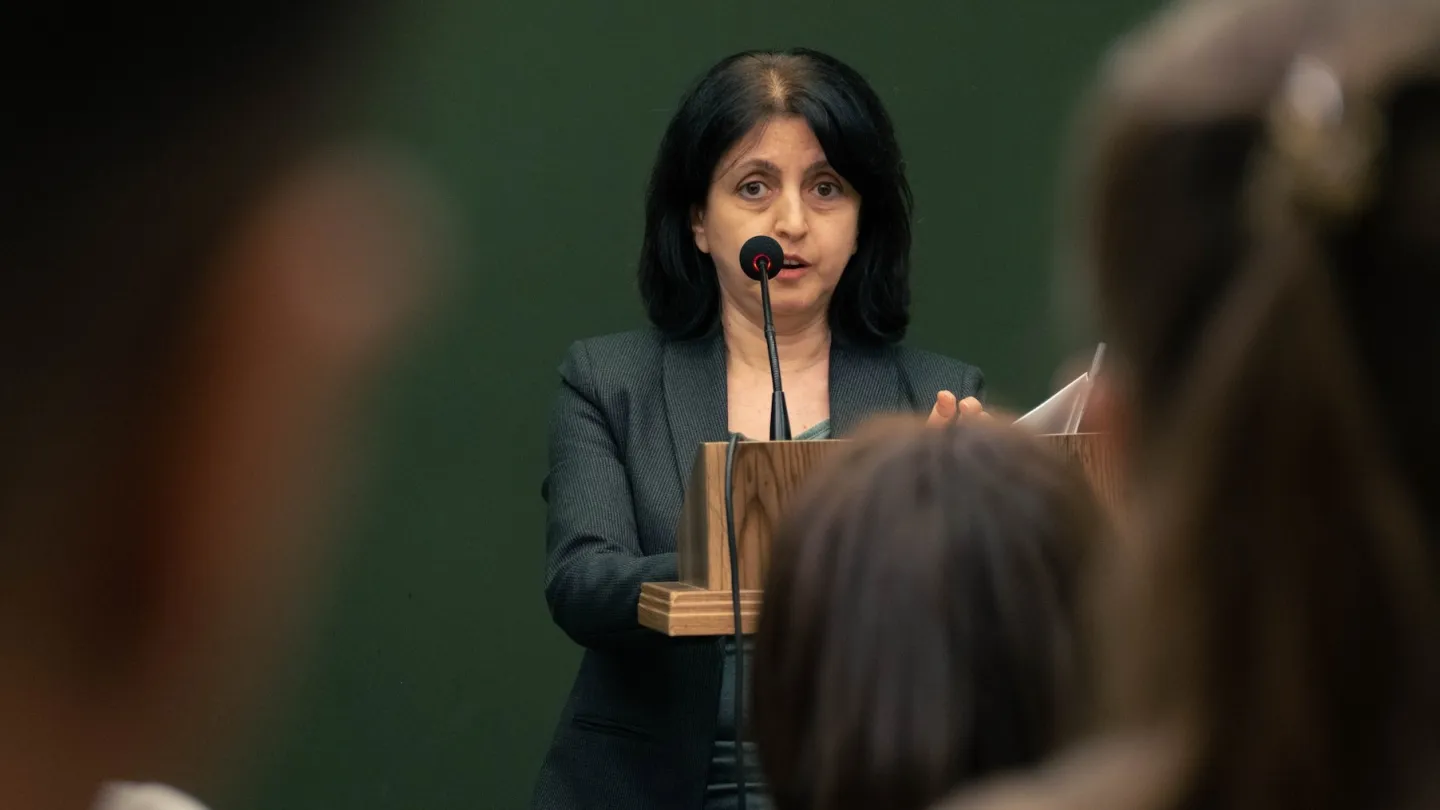 A woman standing at a podium with a mic
