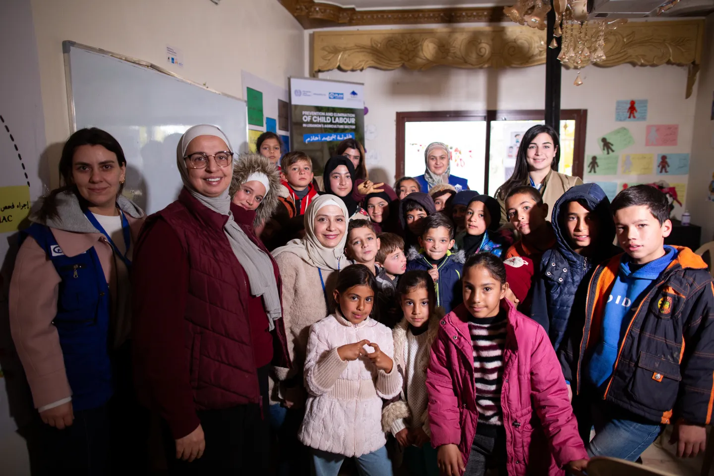 Children alongside ILO officials and their local partners pose for a group photo following an ILO-led session with children engaged in child labour at a local centre in the Bekaa Valley, 15 December 2025. 